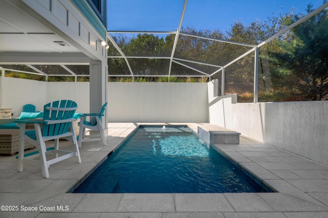 view of pool featuring a patio area, pool water feature, and glass enclosure