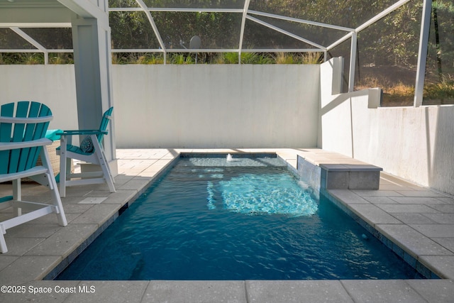 view of swimming pool with pool water feature, a patio, and glass enclosure