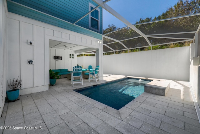 view of swimming pool featuring an outdoor living space, a patio area, and glass enclosure