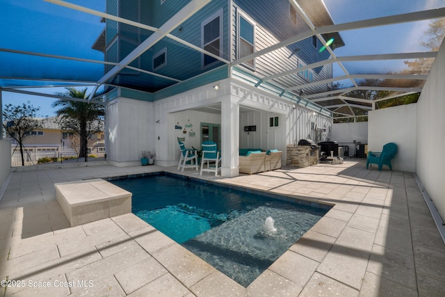 view of pool featuring pool water feature, an outdoor hangout area, a patio area, and glass enclosure