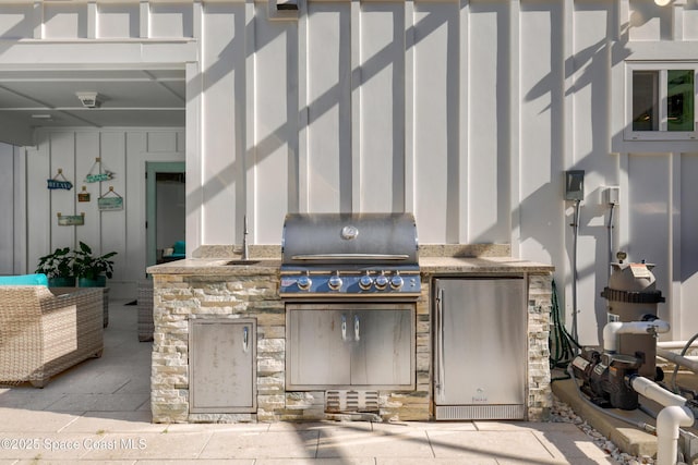 view of patio / terrace with area for grilling, a grill, and sink