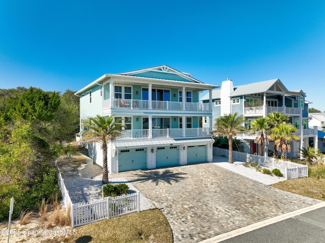 coastal inspired home with a garage and a balcony