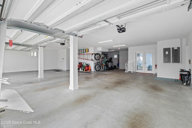 garage with french doors, a garage door opener, and electric panel