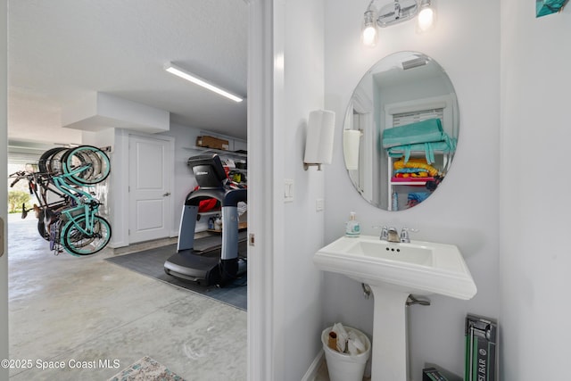 bathroom with concrete floors and a textured ceiling