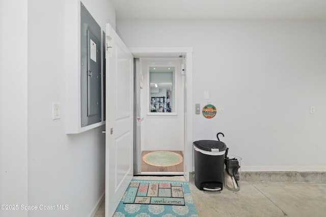 corridor featuring concrete flooring and electric panel