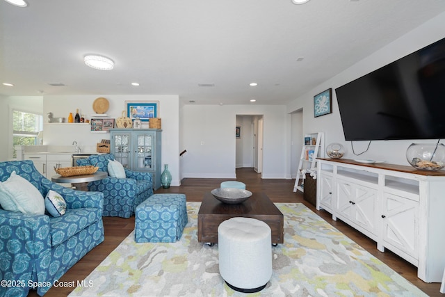 living room with dark hardwood / wood-style floors and sink