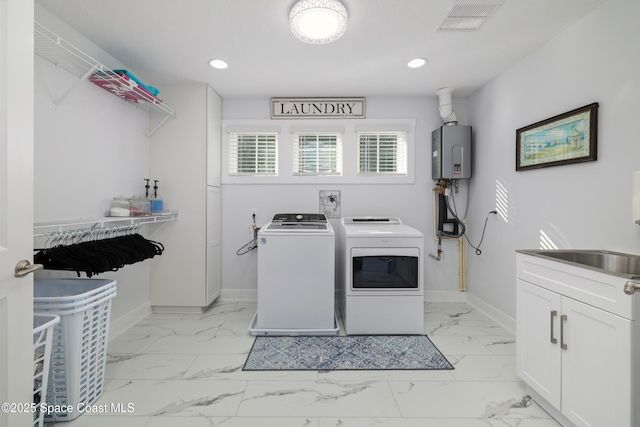 washroom with independent washer and dryer, sink, and water heater