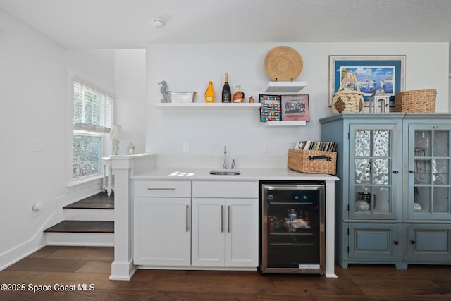 bar featuring white cabinets, sink, wine cooler, and dark hardwood / wood-style flooring