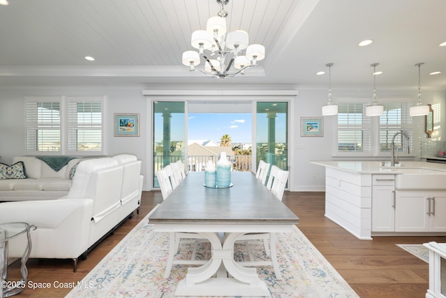 dining area with crown molding, an inviting chandelier, dark hardwood / wood-style floors, and sink