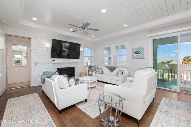 living room featuring plenty of natural light, dark hardwood / wood-style flooring, and a tray ceiling