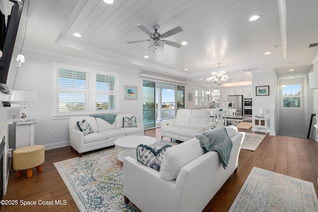 living room with wood ceiling, dark hardwood / wood-style floors, a raised ceiling, and ceiling fan with notable chandelier