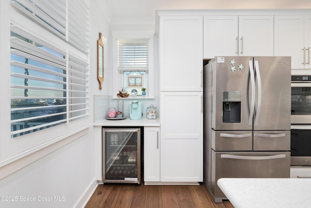 kitchen with wine cooler, dark hardwood / wood-style flooring, stainless steel appliances, decorative backsplash, and white cabinets