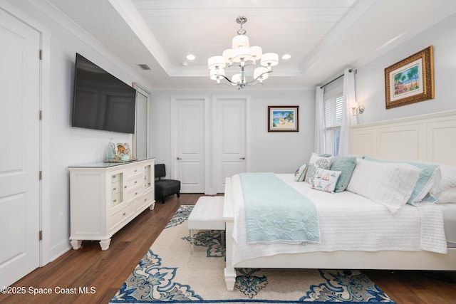 bedroom with crown molding, dark hardwood / wood-style flooring, a raised ceiling, and an inviting chandelier