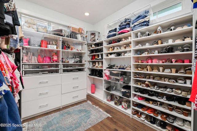 walk in closet with dark wood-type flooring