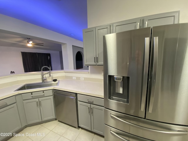 kitchen with light tile patterned floors, sink, appliances with stainless steel finishes, and gray cabinetry