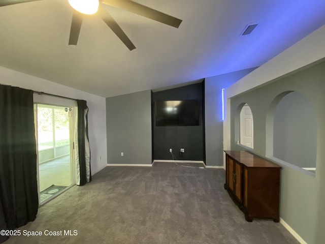 carpeted spare room featuring vaulted ceiling and ceiling fan