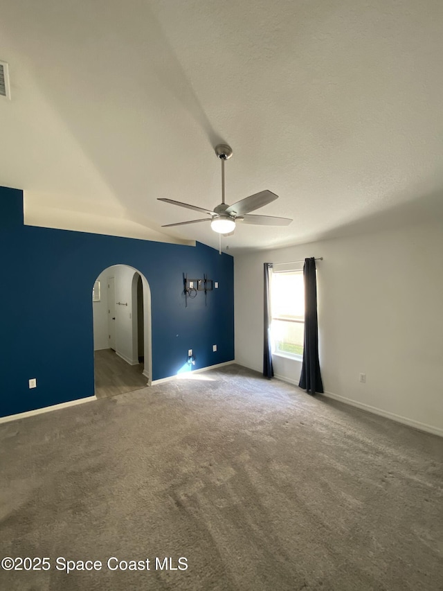 carpeted spare room with a textured ceiling and ceiling fan