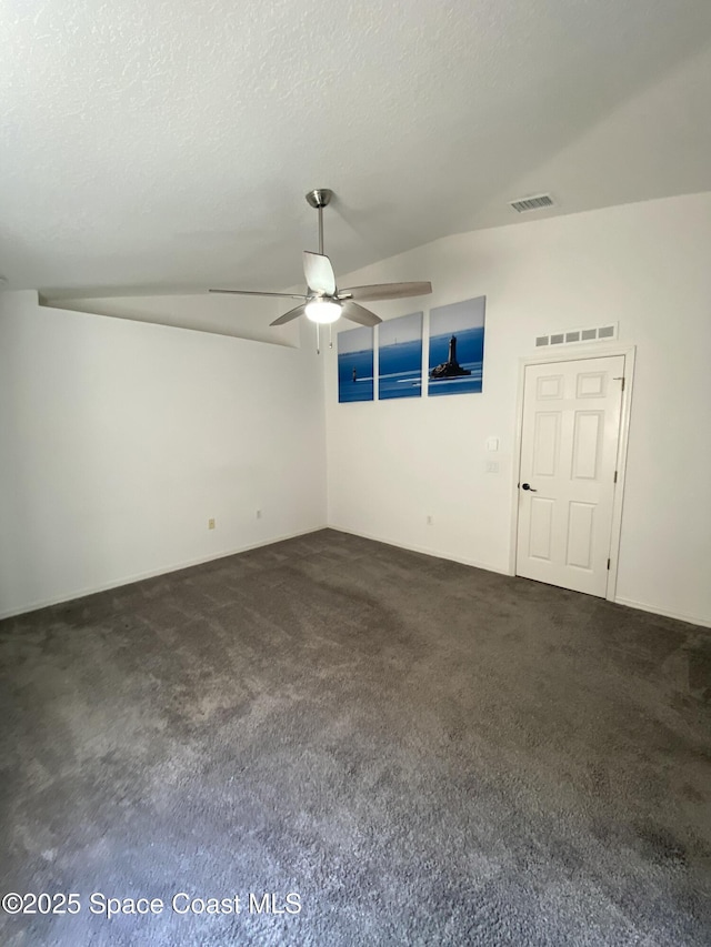 carpeted empty room with ceiling fan, lofted ceiling, and a textured ceiling