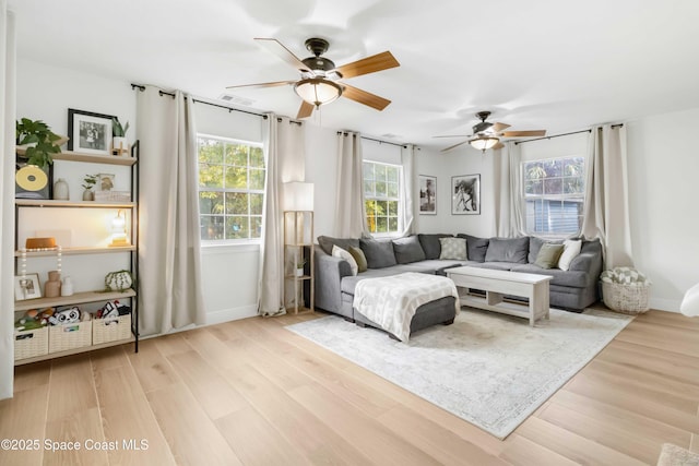 living room with ceiling fan and light wood-type flooring