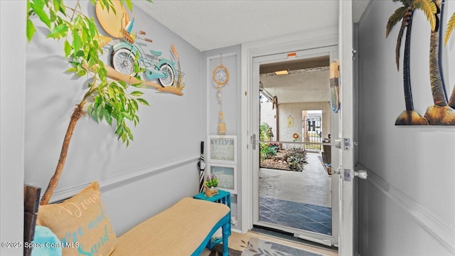 doorway to outside featuring a textured ceiling