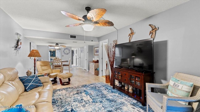 living room featuring a textured ceiling and ceiling fan