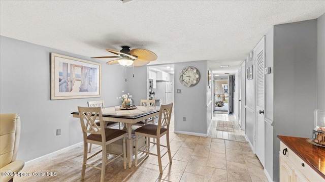 dining space with ceiling fan and a textured ceiling