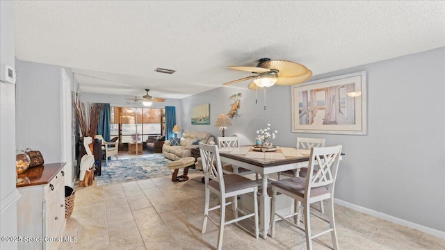 dining space with ceiling fan and a textured ceiling