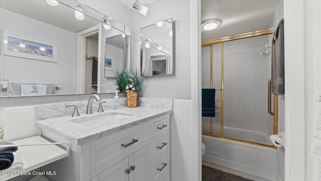 full bathroom featuring vanity, enclosed tub / shower combo, and toilet