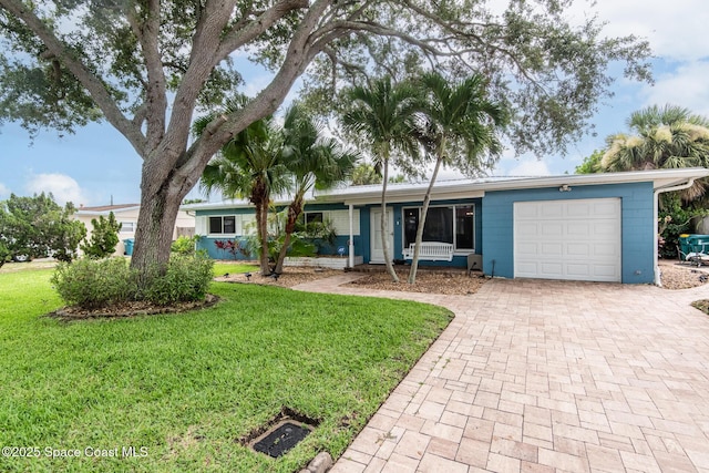 ranch-style home featuring a garage and a front lawn