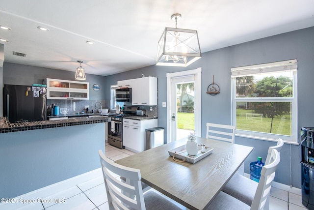 tiled dining room with sink and a healthy amount of sunlight