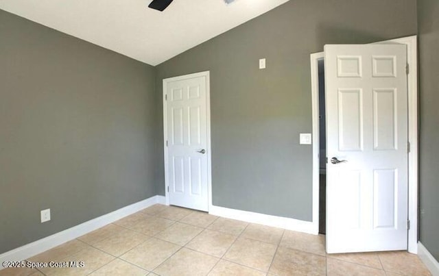 unfurnished bedroom featuring vaulted ceiling and light tile patterned floors