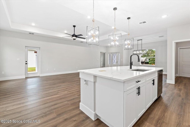 kitchen featuring decorative light fixtures, white cabinetry, a healthy amount of sunlight, an island with sink, and sink