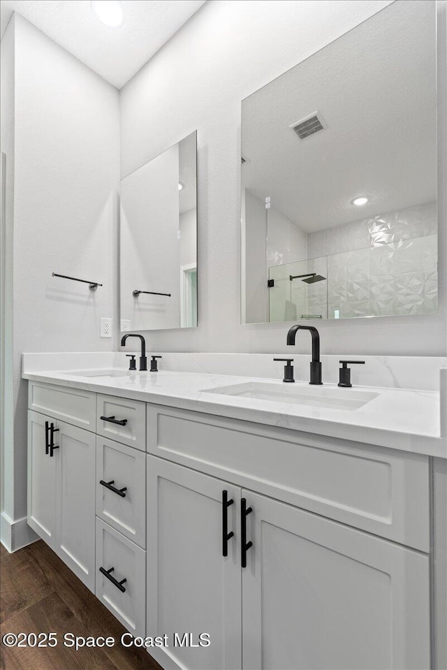 bathroom with vanity, a shower, and wood-type flooring