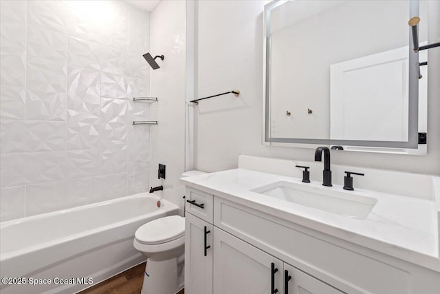 full bathroom featuring vanity, hardwood / wood-style flooring, toilet, and tiled shower / bath combo