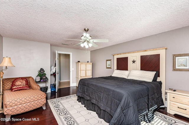 bedroom with dark wood-type flooring, ceiling fan, and a textured ceiling