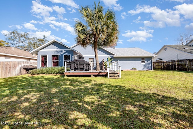 back of house featuring a wooden deck and a lawn