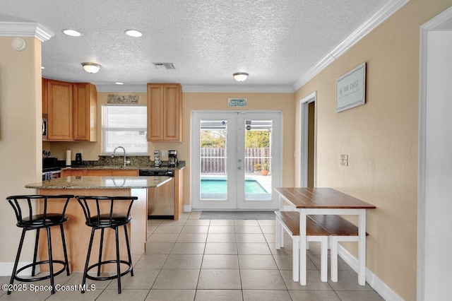 kitchen featuring a wealth of natural light, ornamental molding, french doors, and appliances with stainless steel finishes