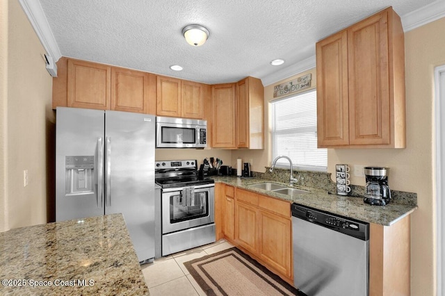 kitchen featuring light stone counters, sink, stainless steel appliances, and light tile patterned flooring