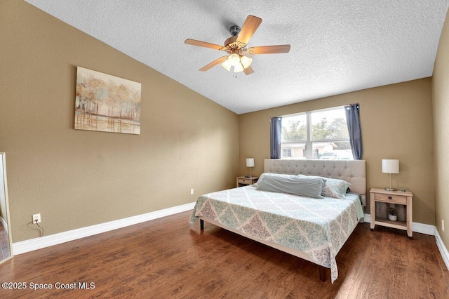 bedroom featuring ceiling fan, dark hardwood / wood-style flooring, vaulted ceiling, and a textured ceiling