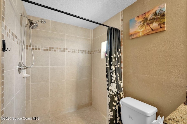 bathroom with toilet, a shower with shower curtain, and a textured ceiling