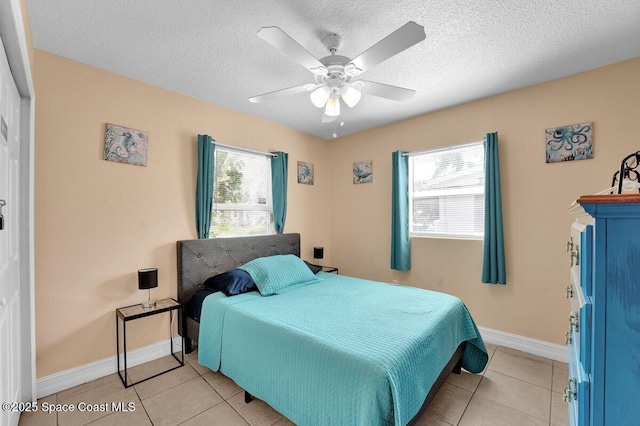 bedroom with ceiling fan, a textured ceiling, and light tile patterned flooring