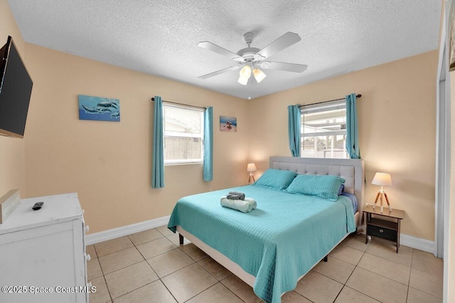 bedroom featuring a textured ceiling, multiple windows, and light tile patterned floors