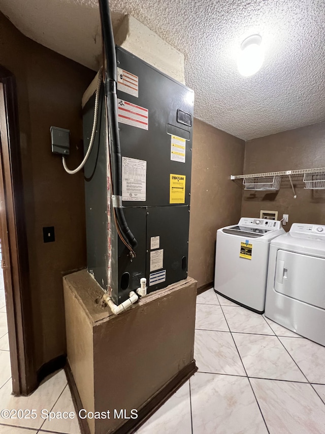 laundry room with a textured ceiling and washer and dryer