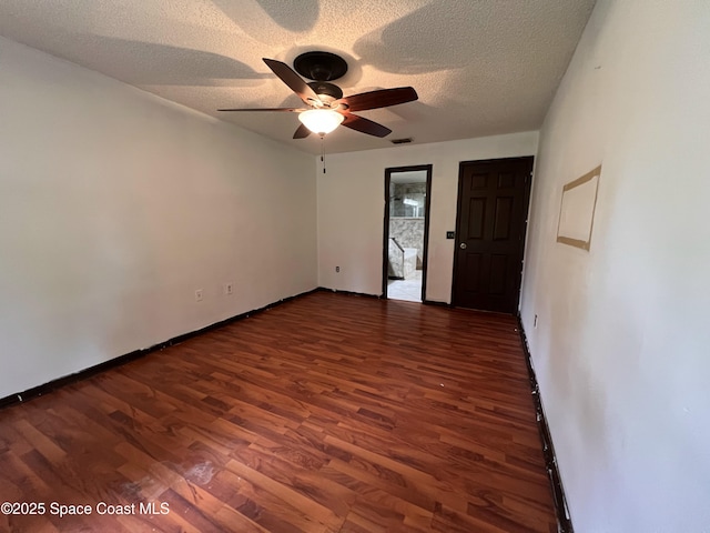 spare room with a textured ceiling, dark hardwood / wood-style floors, and ceiling fan