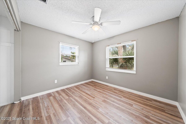 unfurnished room featuring ceiling fan, wood finished floors, baseboards, and a textured ceiling