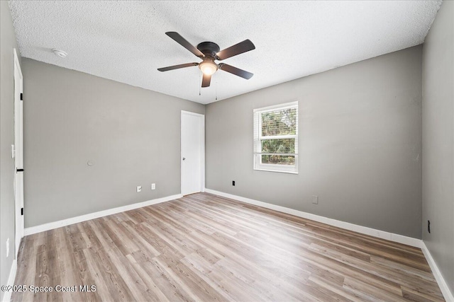 empty room featuring baseboards, a textured ceiling, ceiling fan, and light wood finished floors