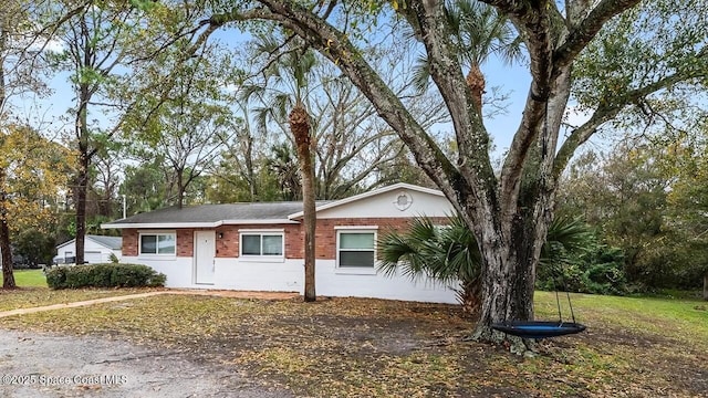 single story home featuring brick siding