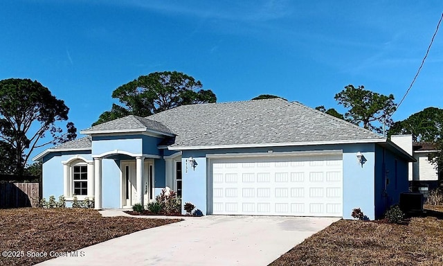 ranch-style house featuring cooling unit and a garage