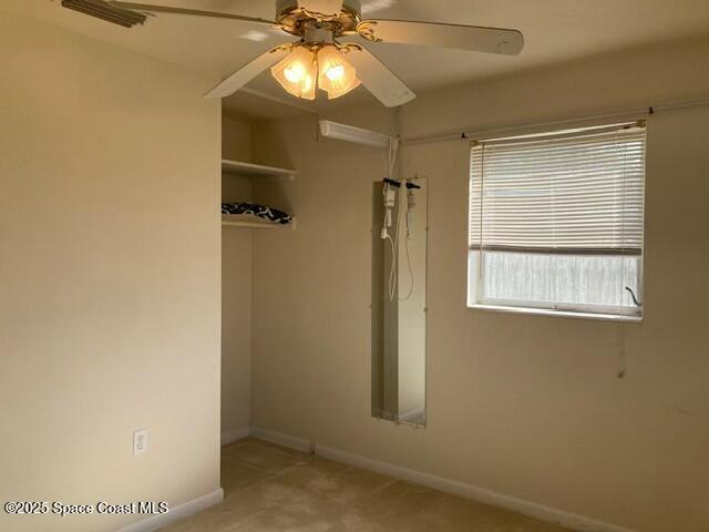 unfurnished room with ceiling fan and carpet flooring