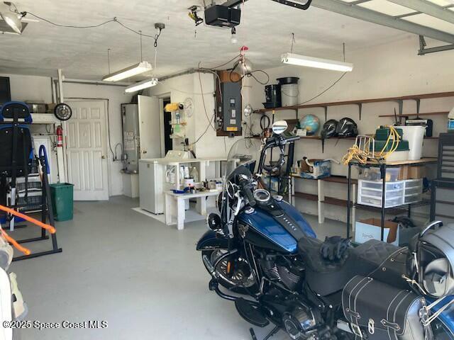 garage with a garage door opener, electric panel, and water heater